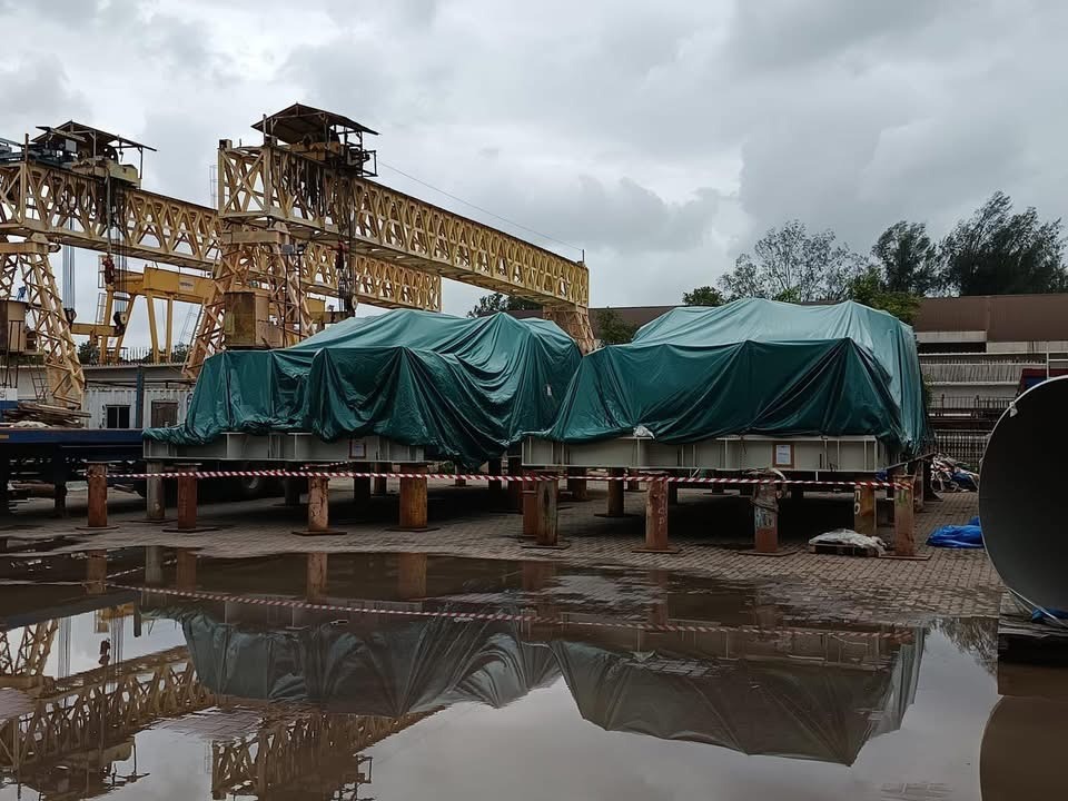 Large covered industrial cargo stored in an open yard