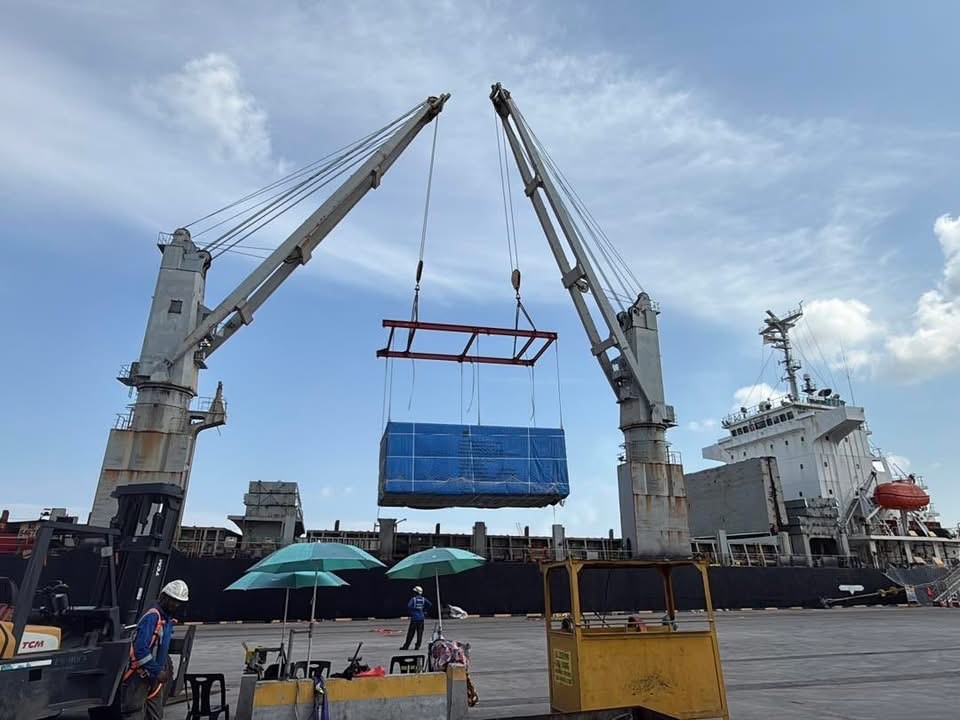 Ship cranes lifting covered project cargo at the port