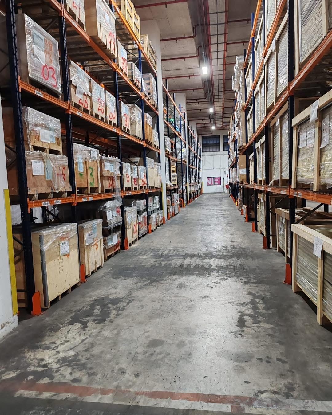 Warehouse aisle lined with pallet racking and stored cargo